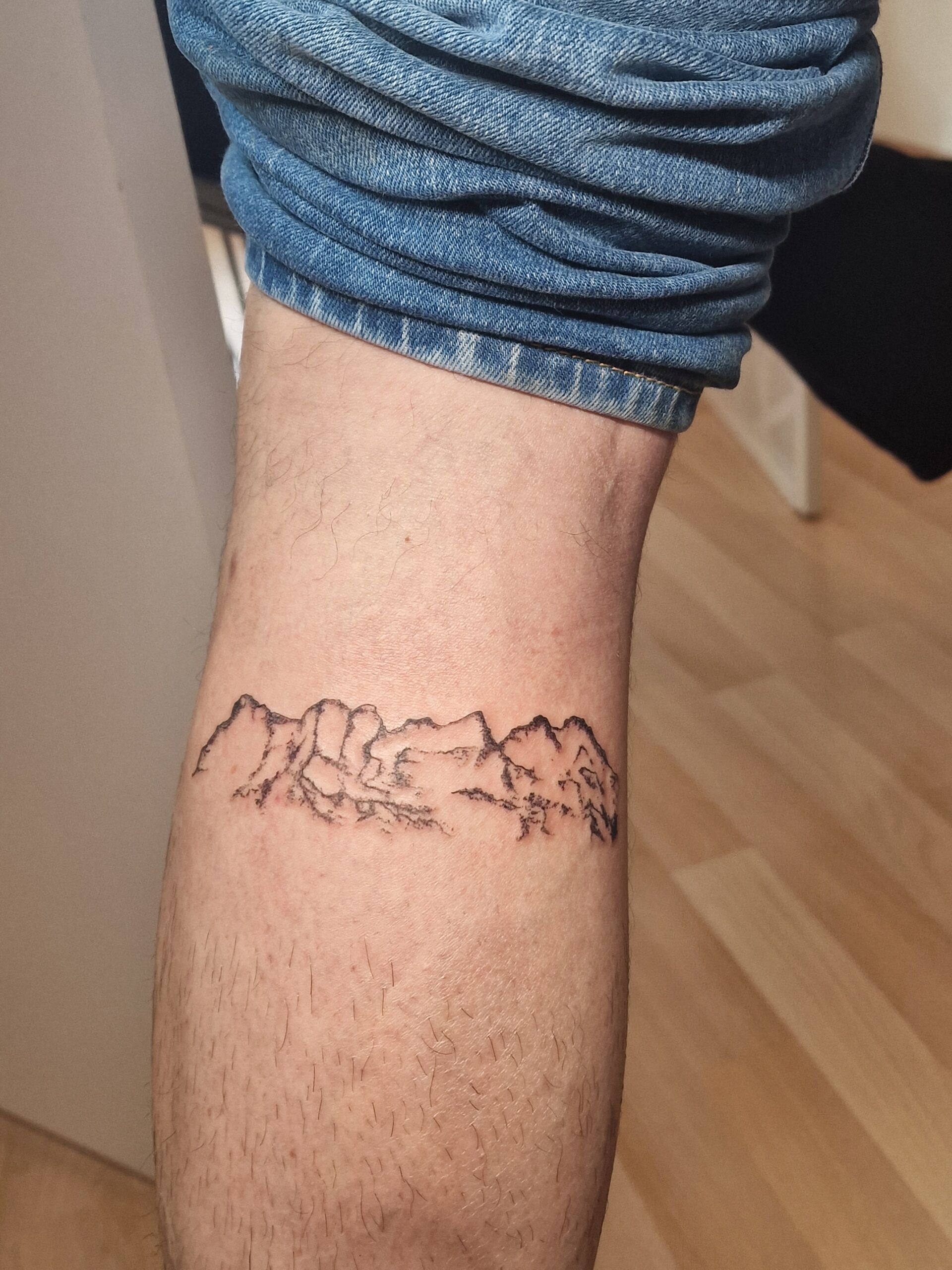 Tatouage de paysage montagneux sur la jambe, réalisé par By Meloun